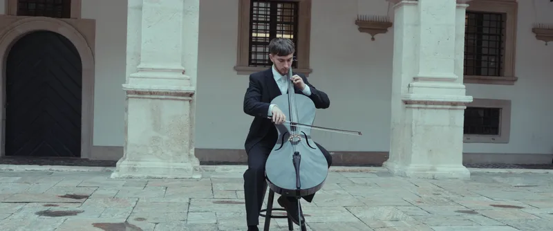 Vito spielt Cello im Innenhof eines historischen Palais