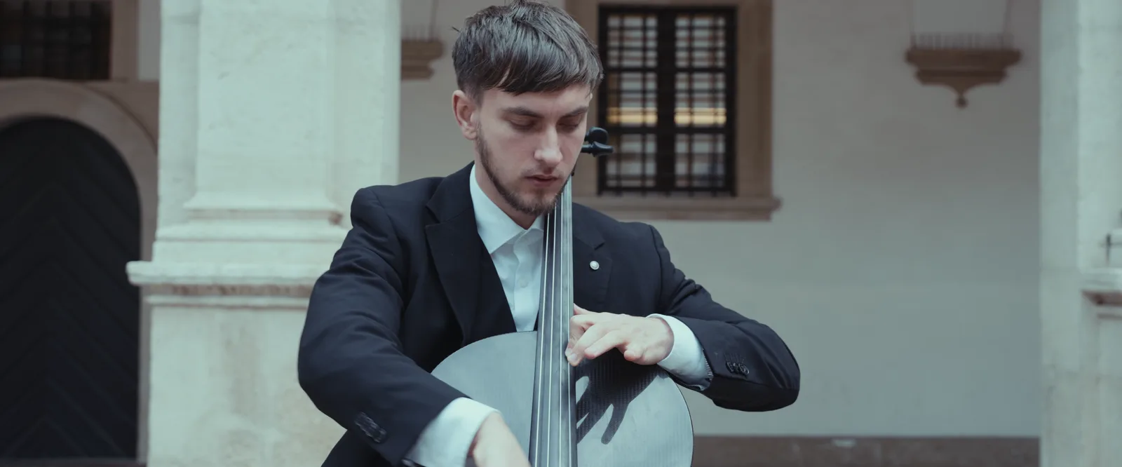 Vito spielt Cello, umrahmt von Säulen